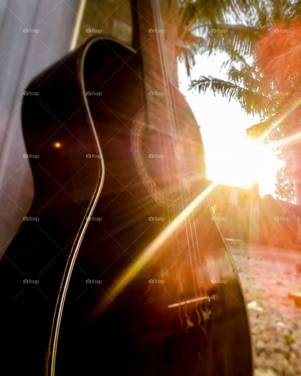 Sun illuminating acoustic guitar