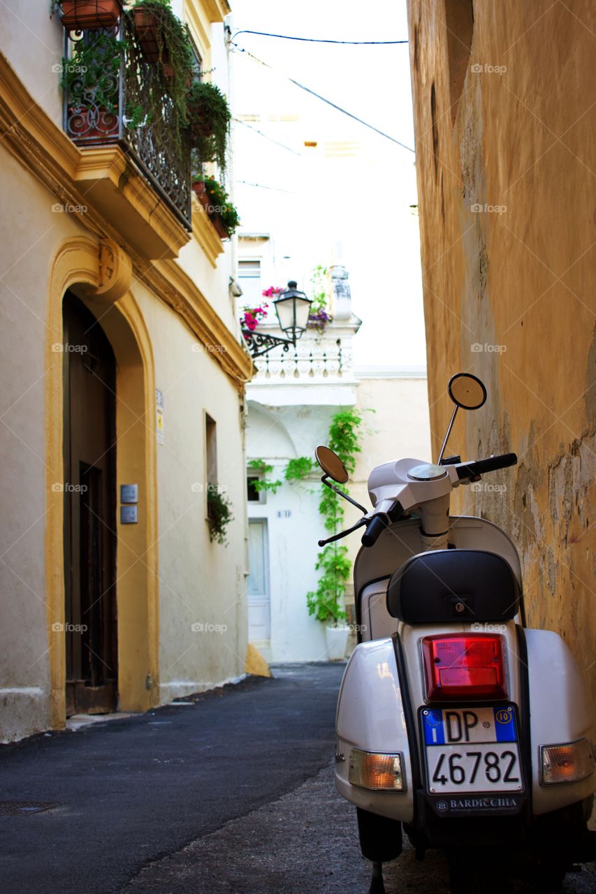 Classic Italian Piaggio parked outside old sea side house