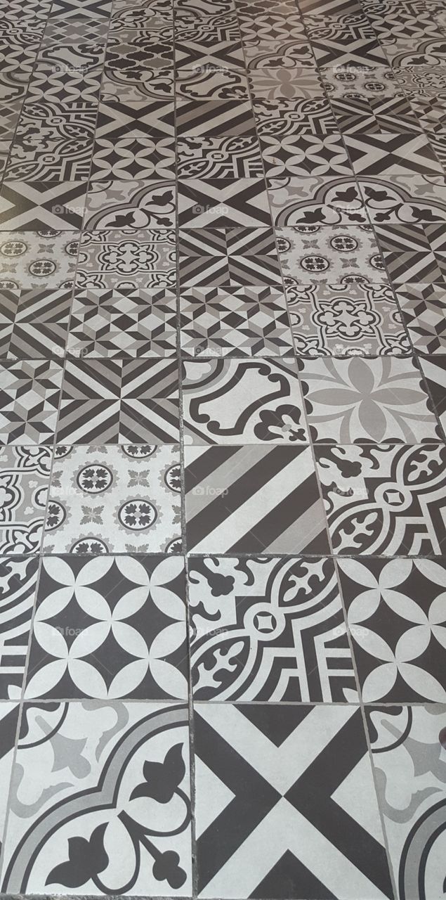 the tiled floor of a cafe inside the Guadalajara airport. it was all black and white with different tile designs