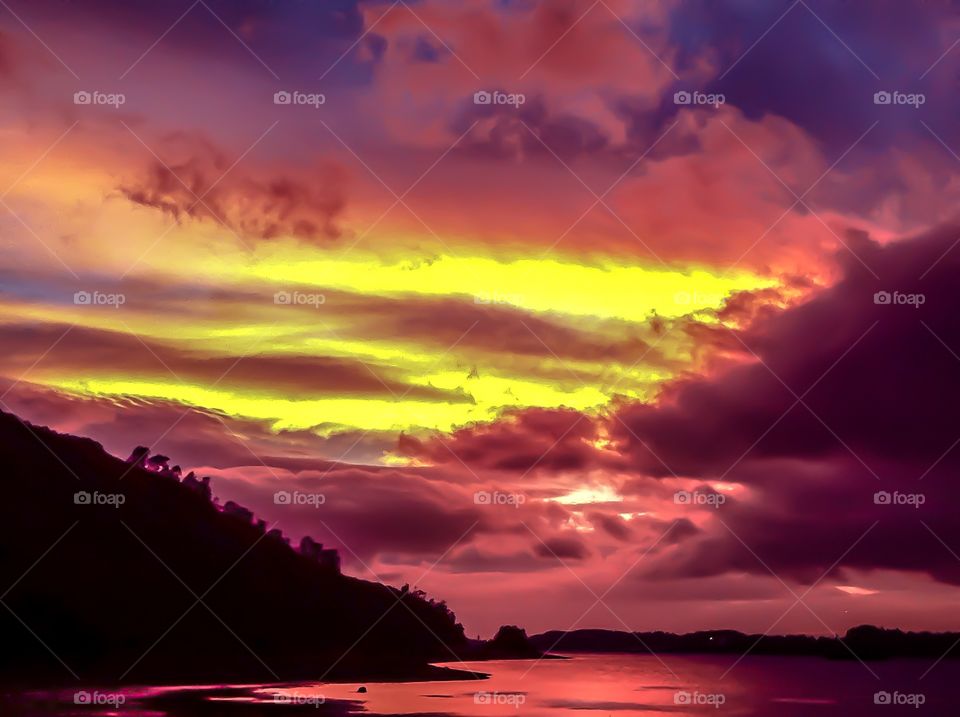 Dramatic sky during sunset over lake and mountain