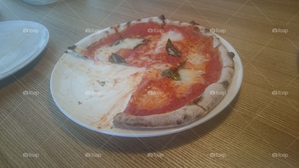 Pizza with missing slice on plate