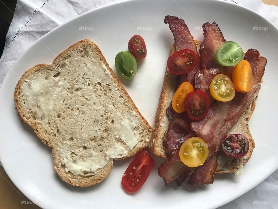 Making bacon and cherry tomato sandwich