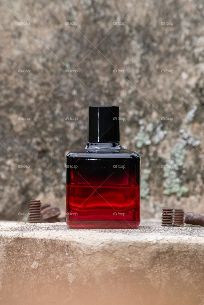 Perfume bottle on a stone. Close-up. Perfume advertising concept