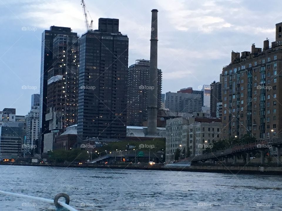 The skyscrapers of Manhattan‘s Upper East Side at twilight time can be seen from aboard our sailboat „Salvation“ as we journeyed south towards Newtown Creek in LIC, Queens, NY. 2017. Hypnotic Productions