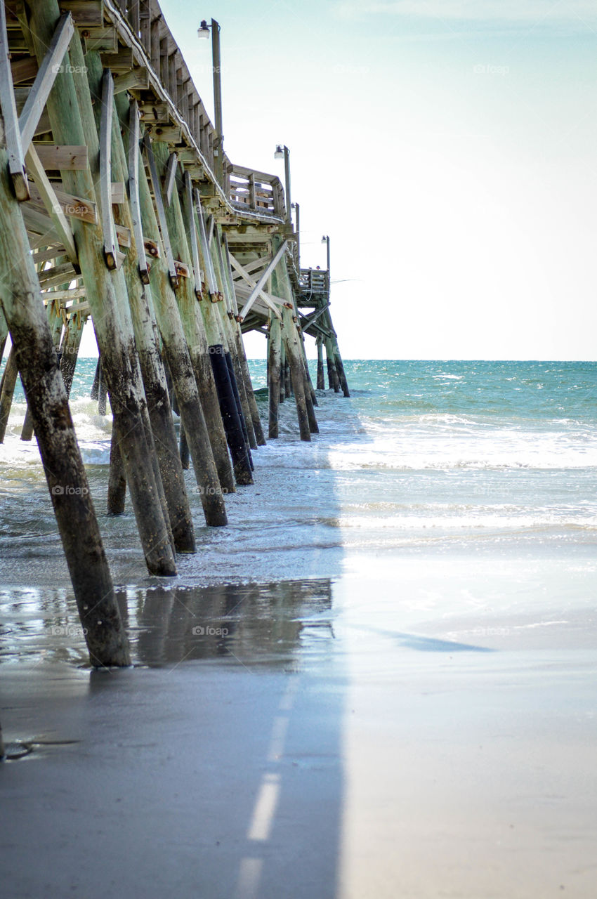 Long view of a wooden pier in the ocean at Surfside Beach, South Carolina, United States