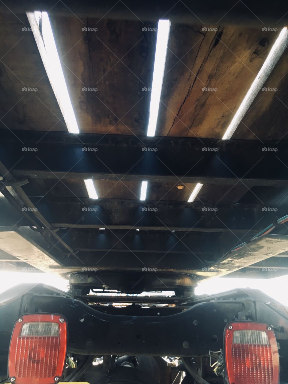 Trailer from under, red lights, wood, lines and light in Florida 