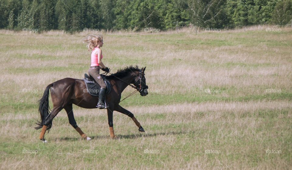 Girl jumps on the horses on the field