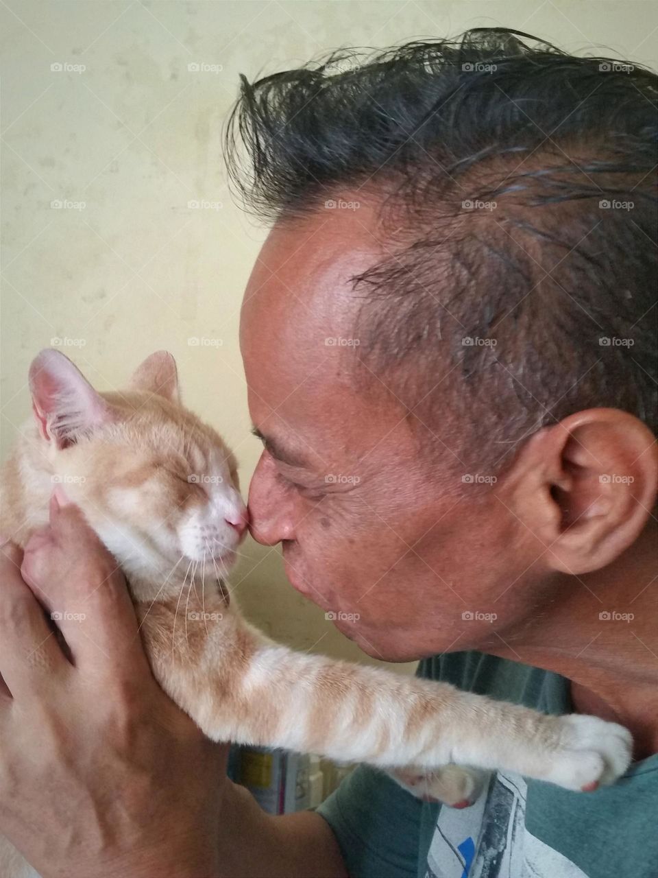 Man give a nose kisses to a cat.