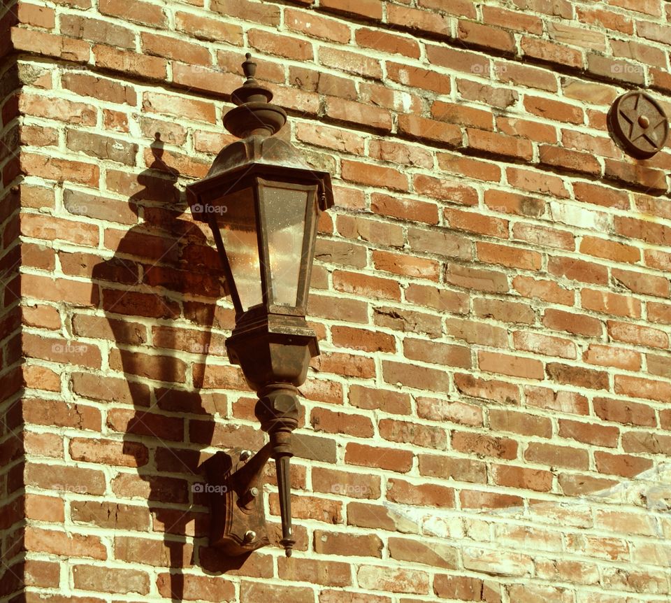 rusty light on the wall ,with bricks as a backdrop