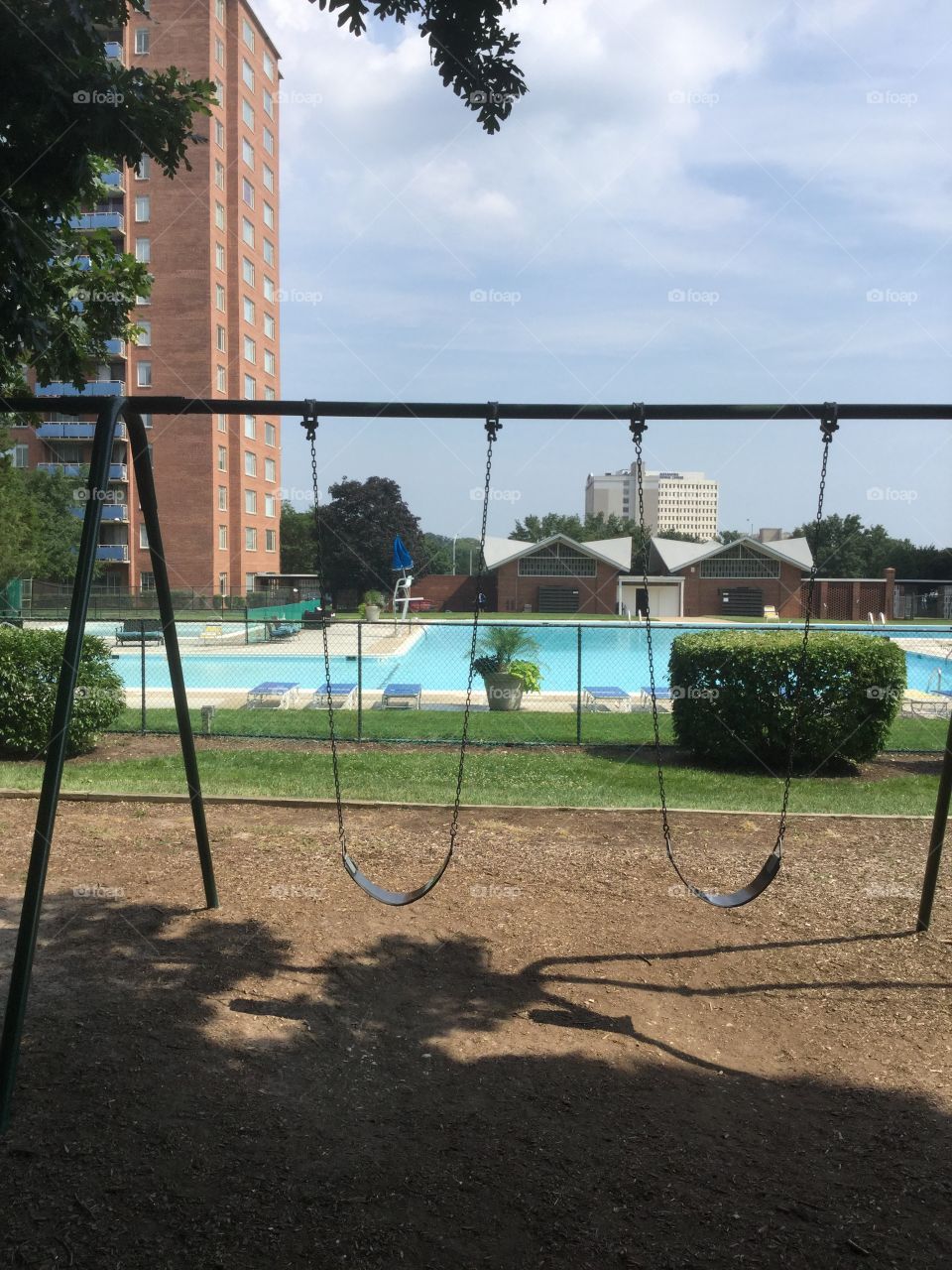 Playground with swings and swimming pool 