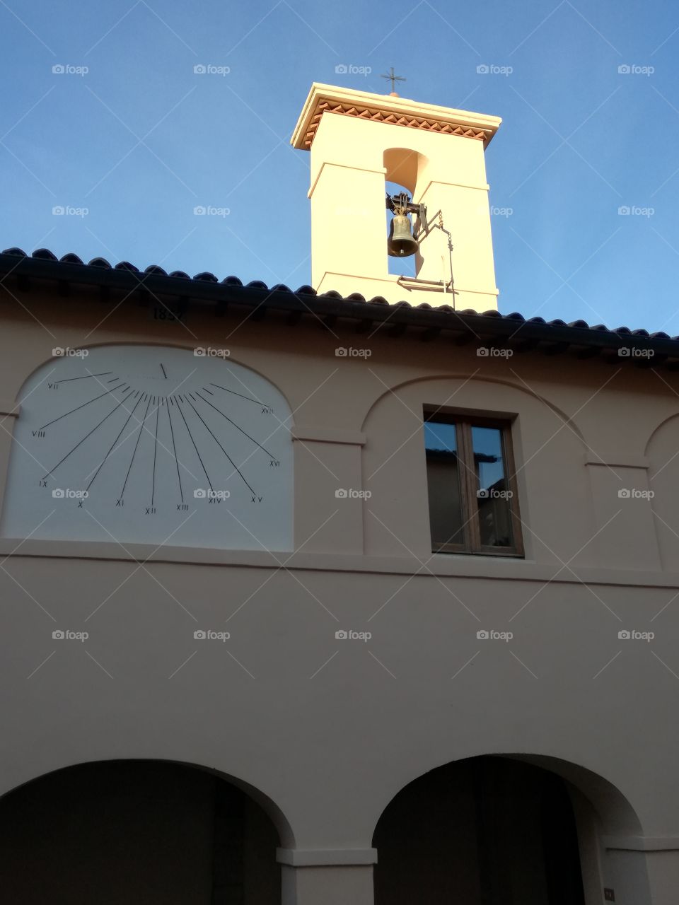 In the cloister: sundial and bell