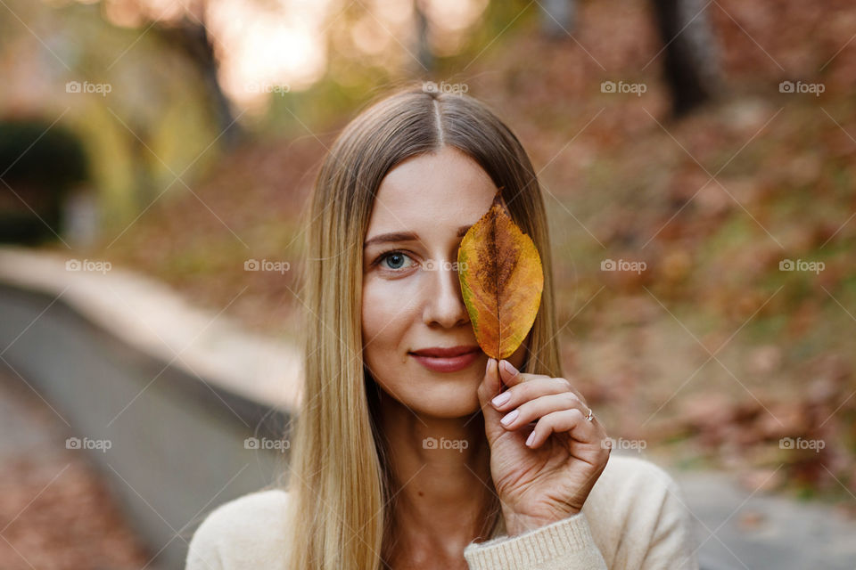 Portrait of beautiful young woman in the autumnal park