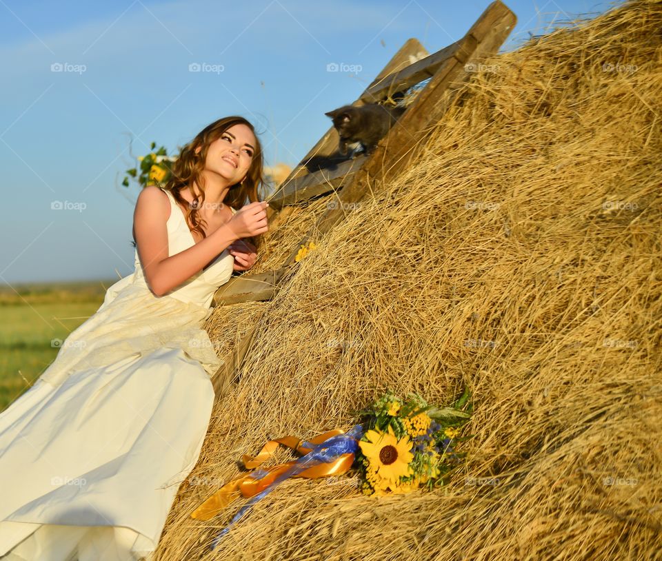 девушка невеста улыбается котенку на сене