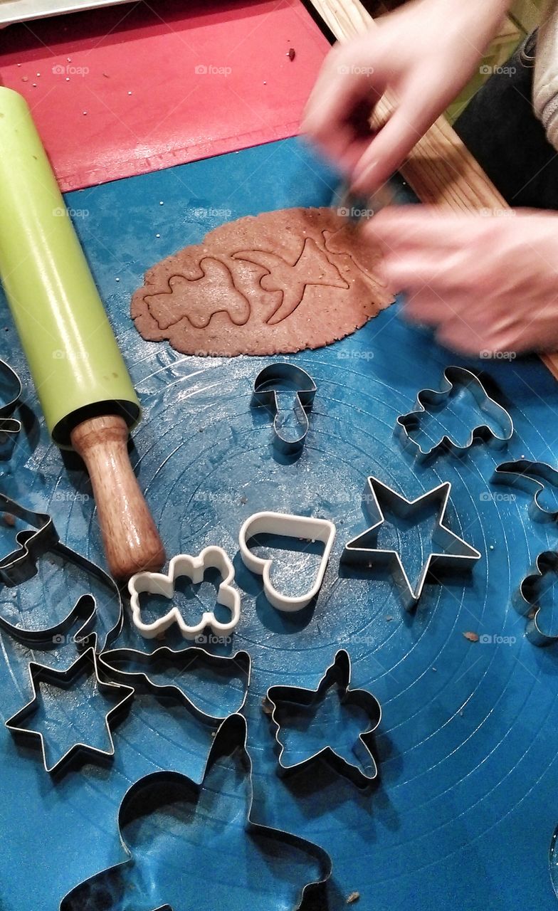 Fresh gingerbread cookie dough, rolled out, with cookie cutters.