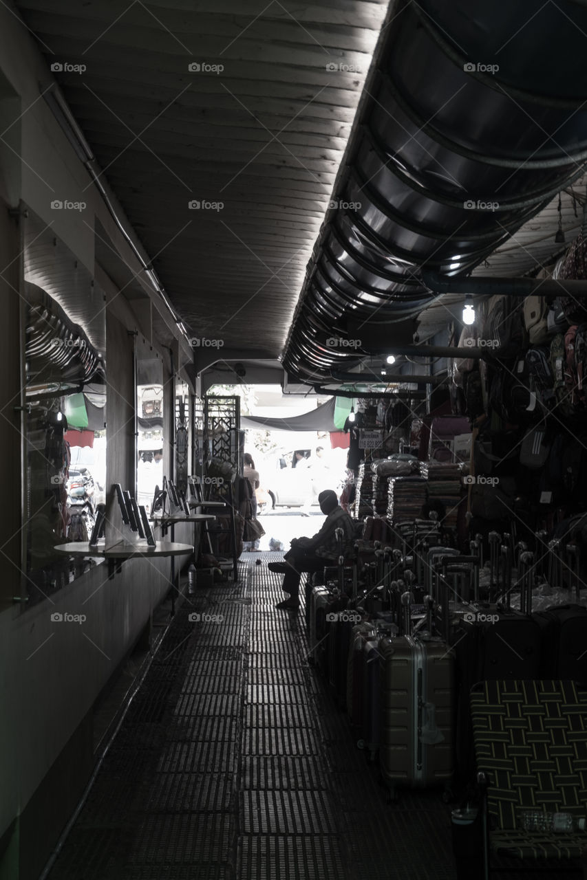 Man sitting in the dark alley in an Asian market