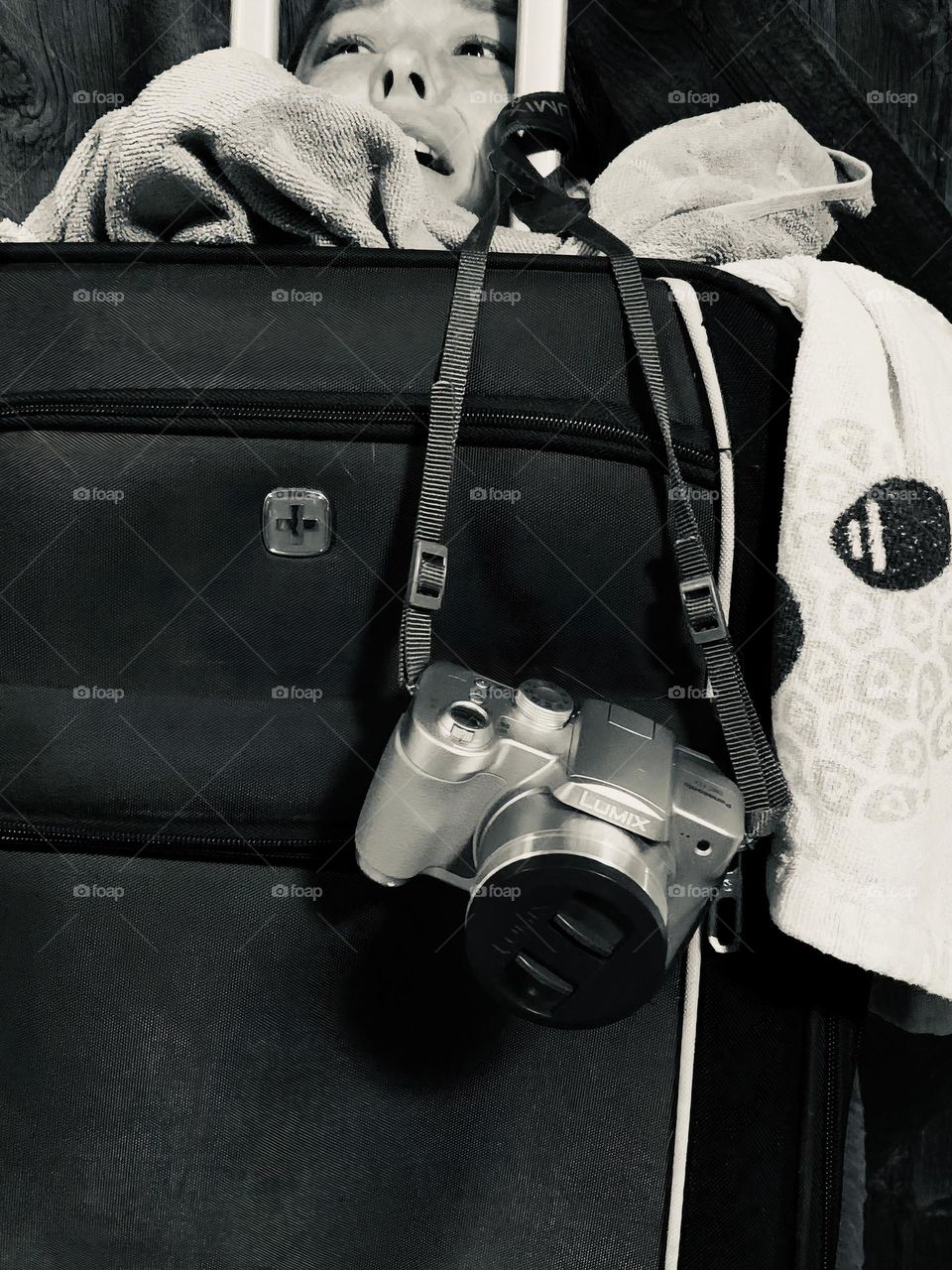 Things to bring in a trip but not to get cut into bringing too much. Luggage, towels, camera and more! Black and white.