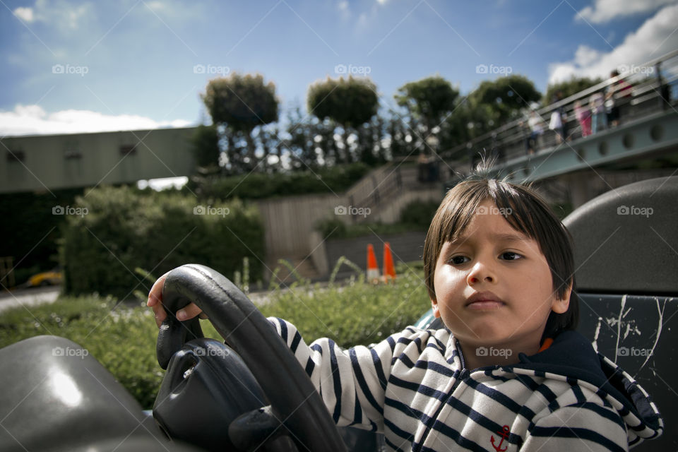 young boy driving a car . Thitiwin behind the wheel 