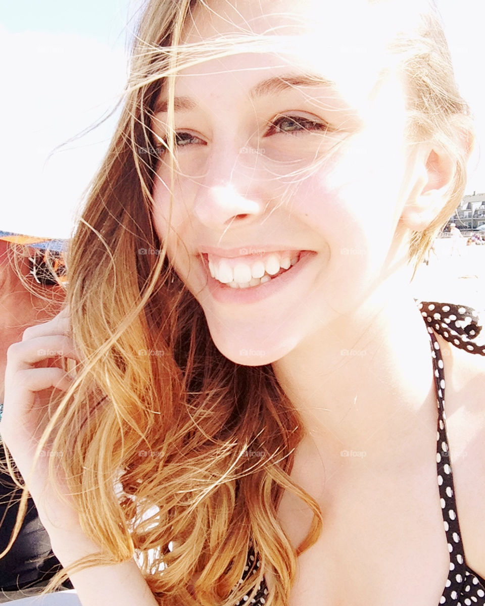 Give us a big smile, beautiful girl sunsplashed at the beach