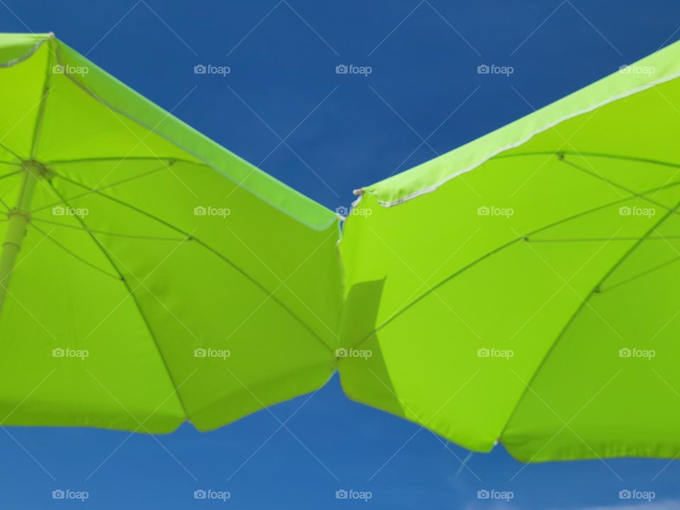 green umbrellas and blue sky