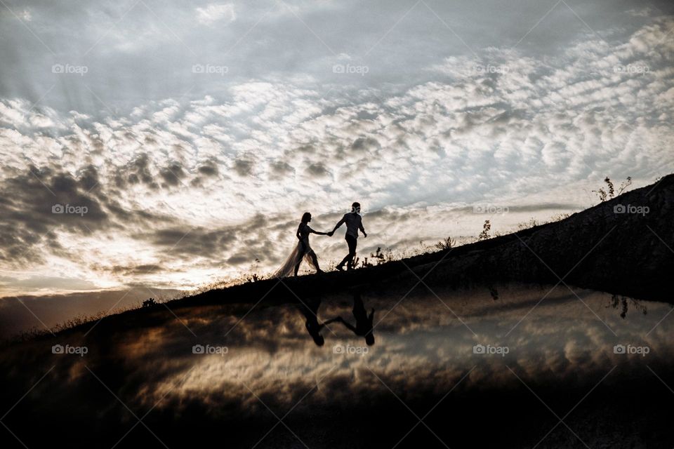 Couple in love walking in mountains on beautiful sunset