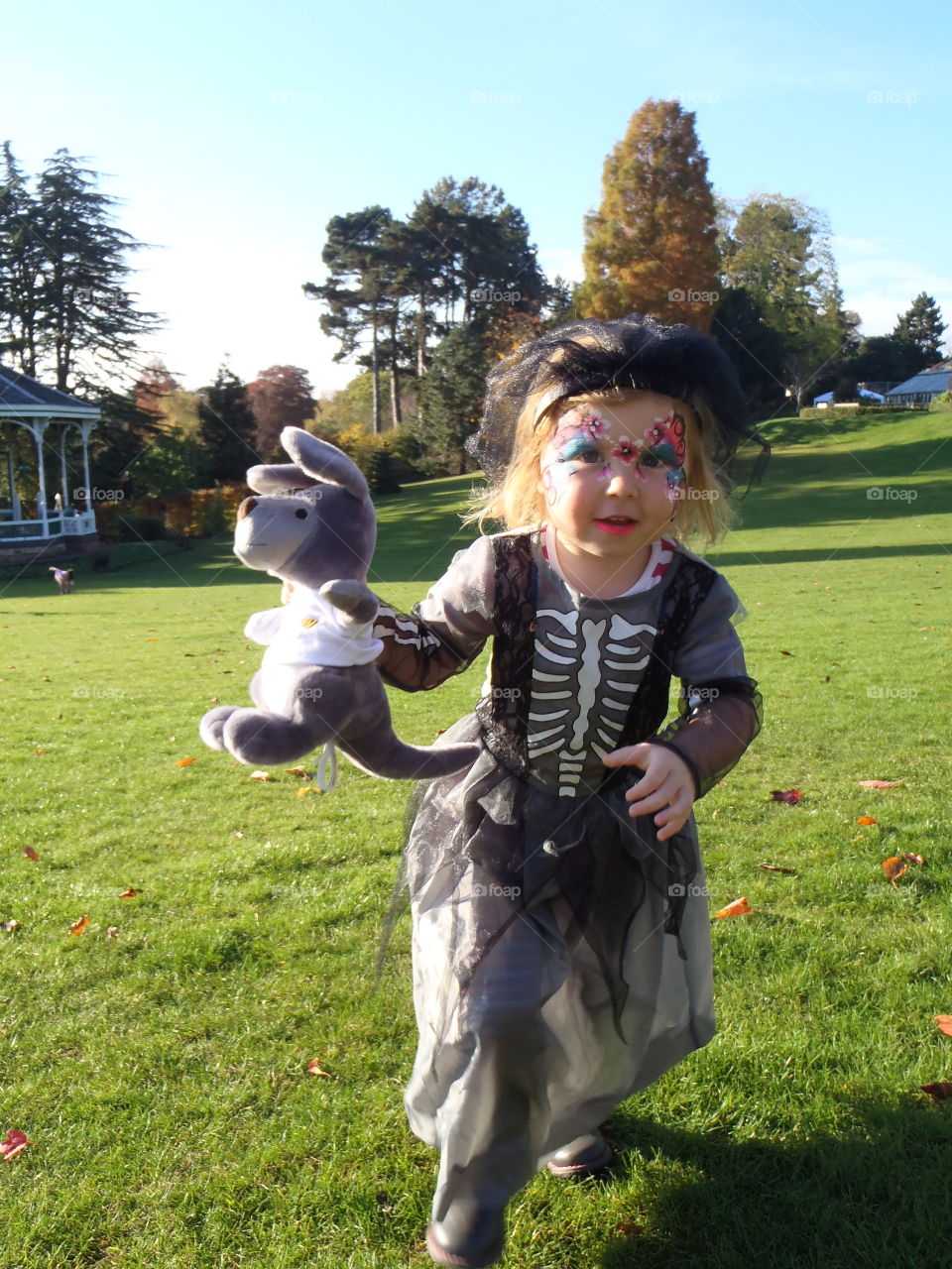 Girl holding toy and walking on grassy land