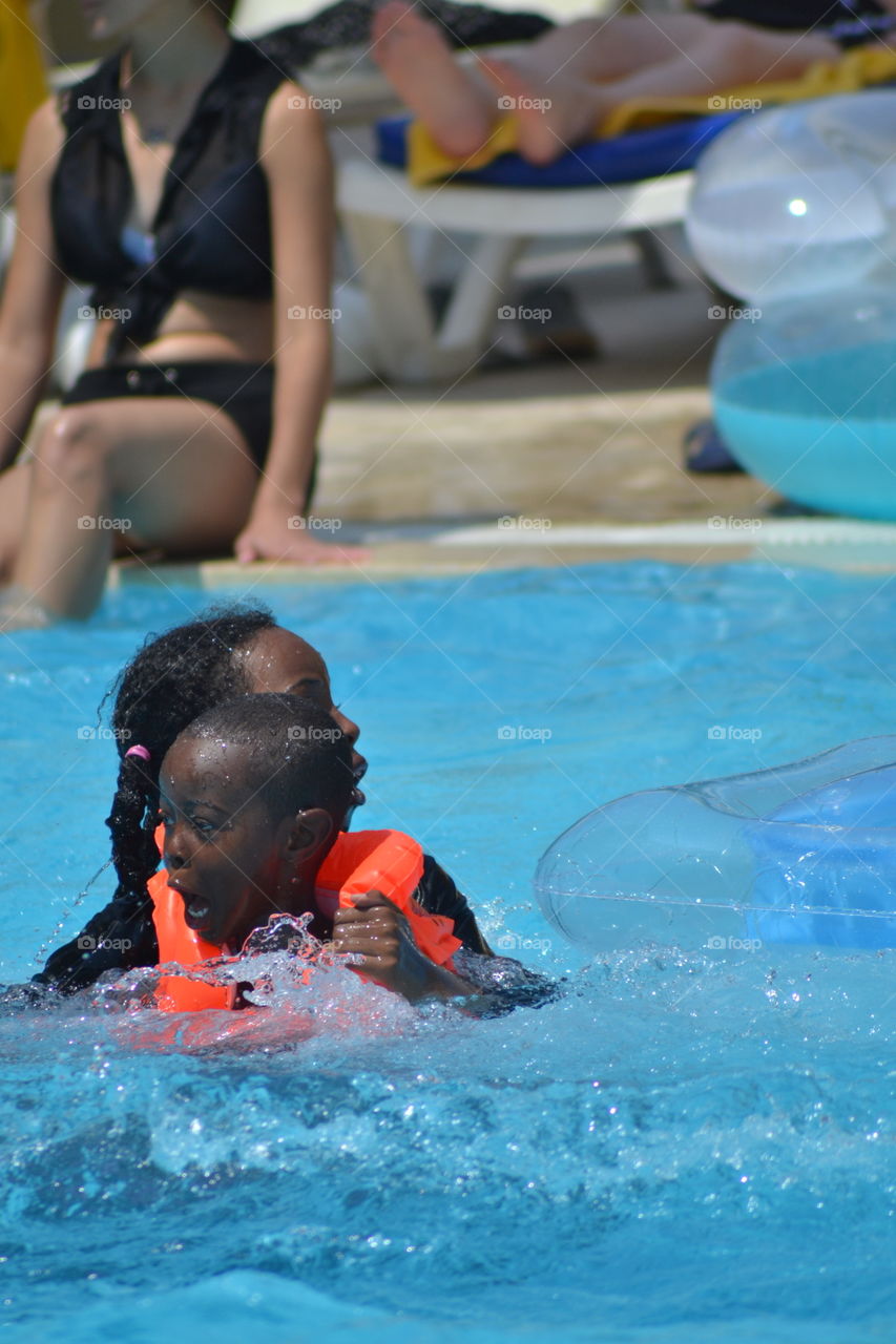 children with life jacket worn in a swimming pool