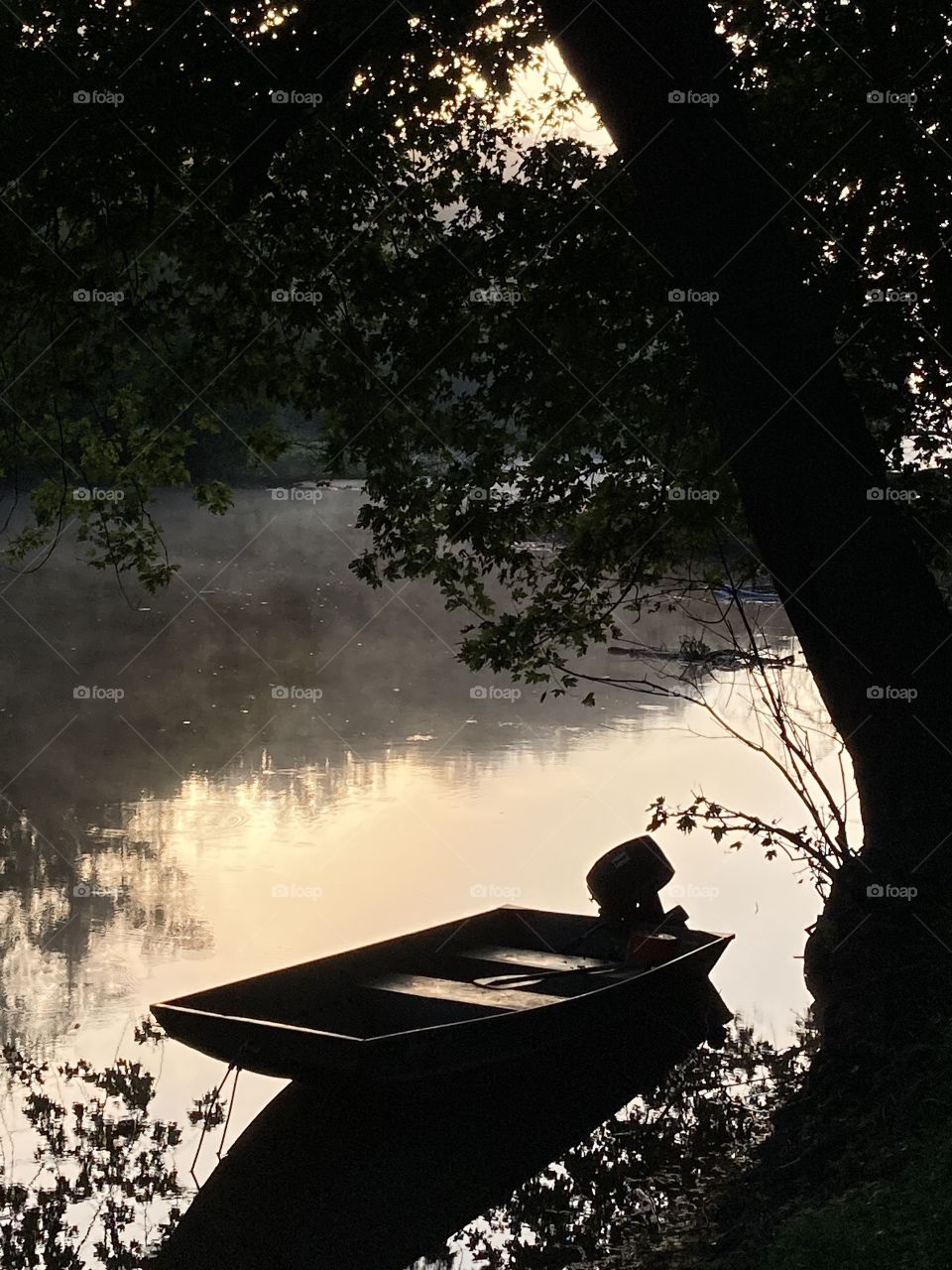 Peaceful morning sunrise silhouettes fishing boat