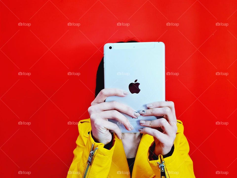 girl with covered face uses her Ipad