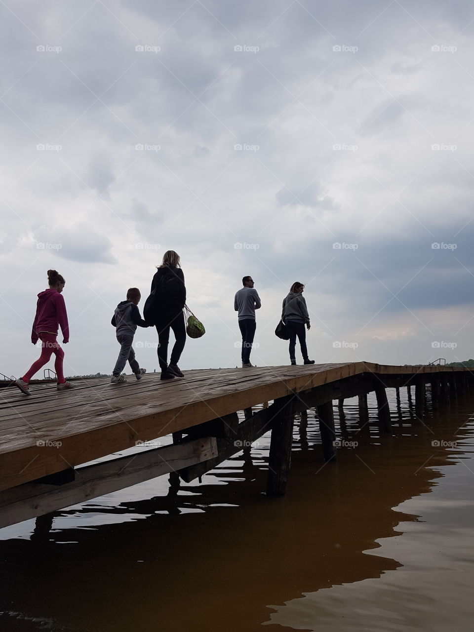 people walking on lake dock