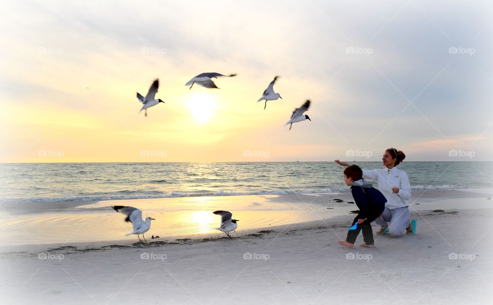 Woman with her son feeding birds