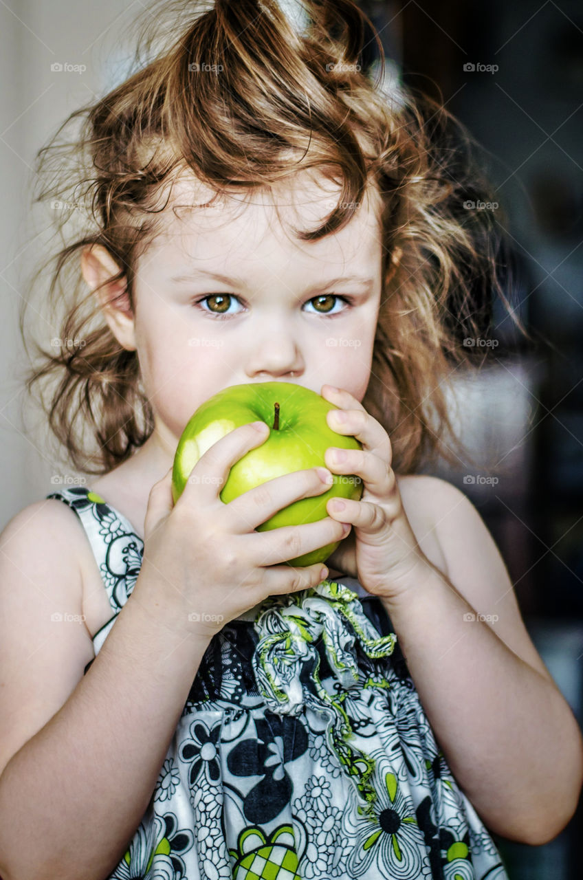 Girl eating green apple