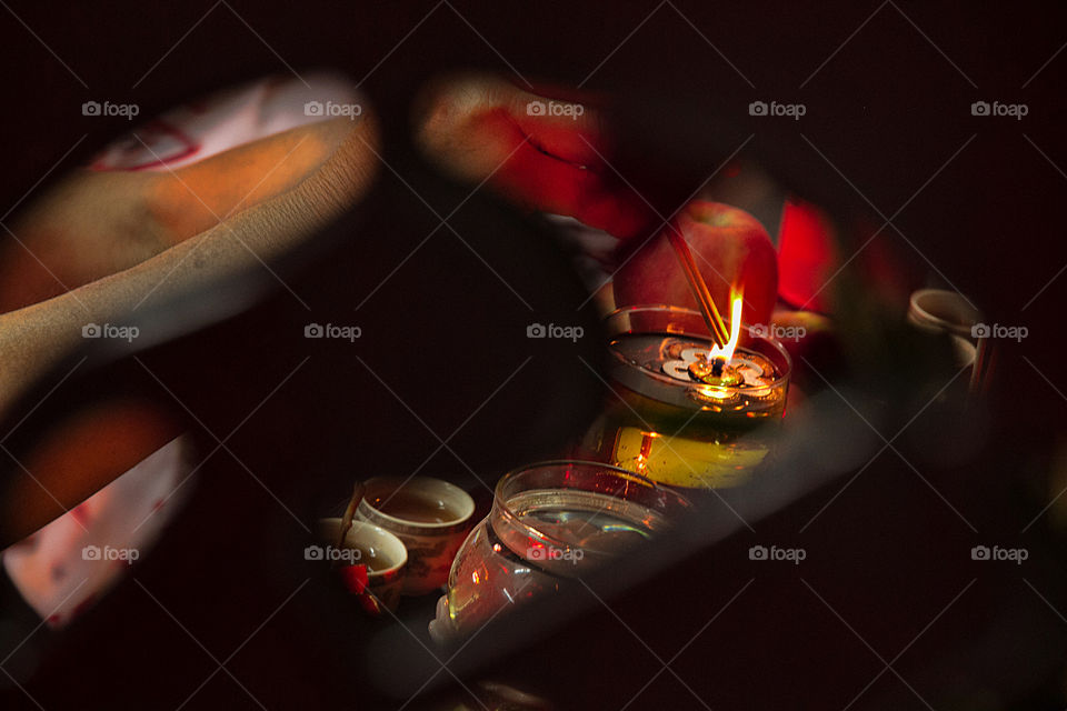 Person's hand burning incense stick