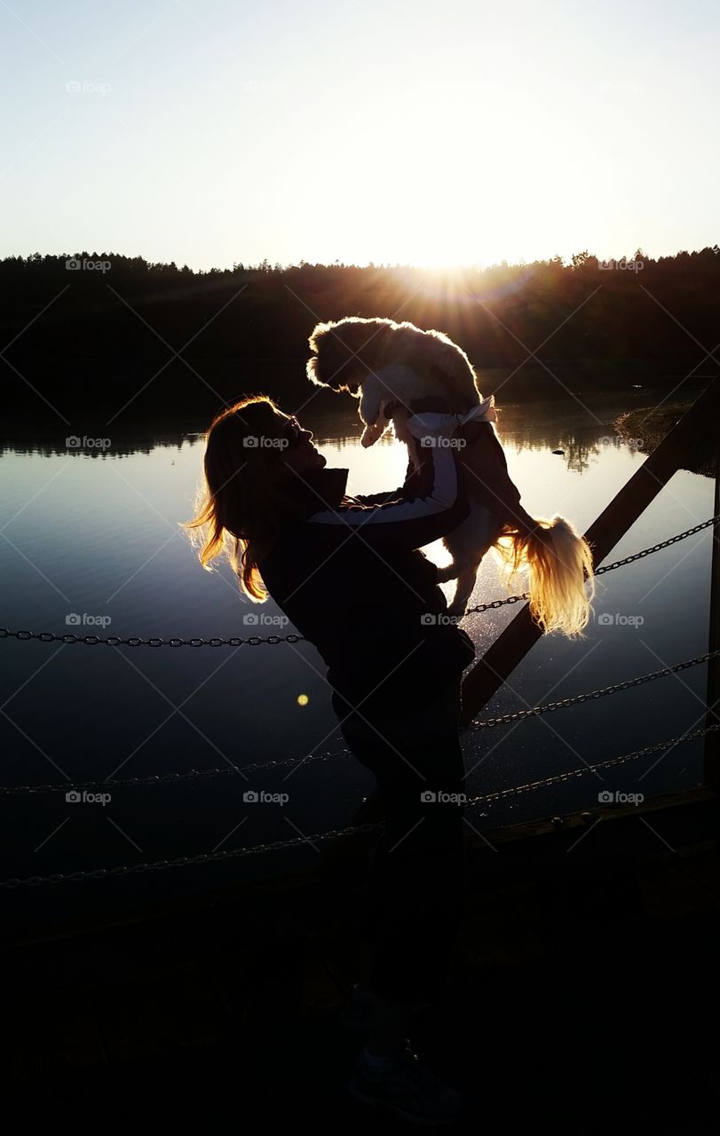 Lion King. dog being held up by woman in silhouette 