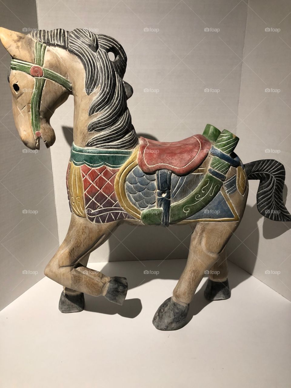 Antique looking wooden horse sculpture with vibrant colours