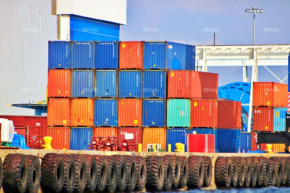 A colorful boat dock with colorful storage containers.
