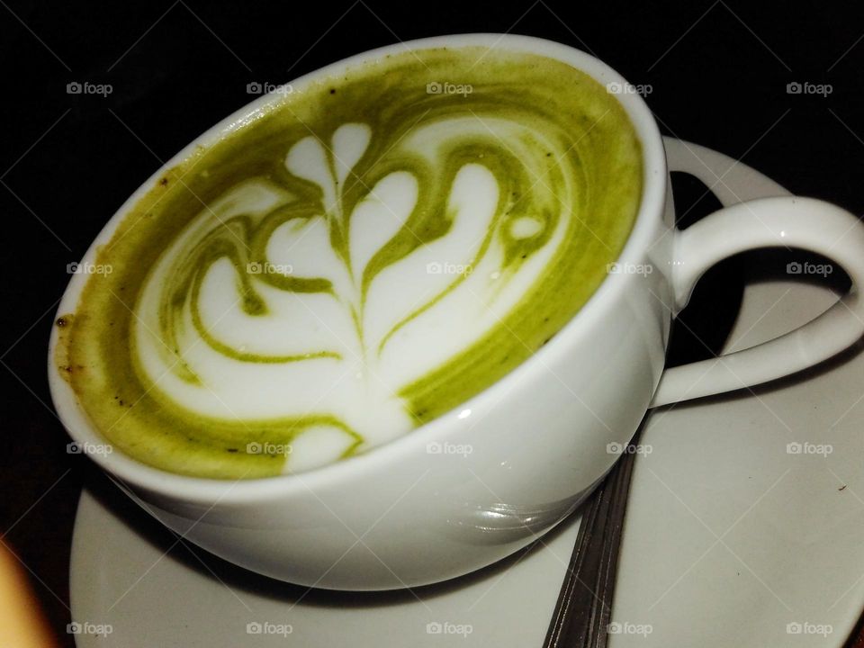 A cup of hot green tea latte at night