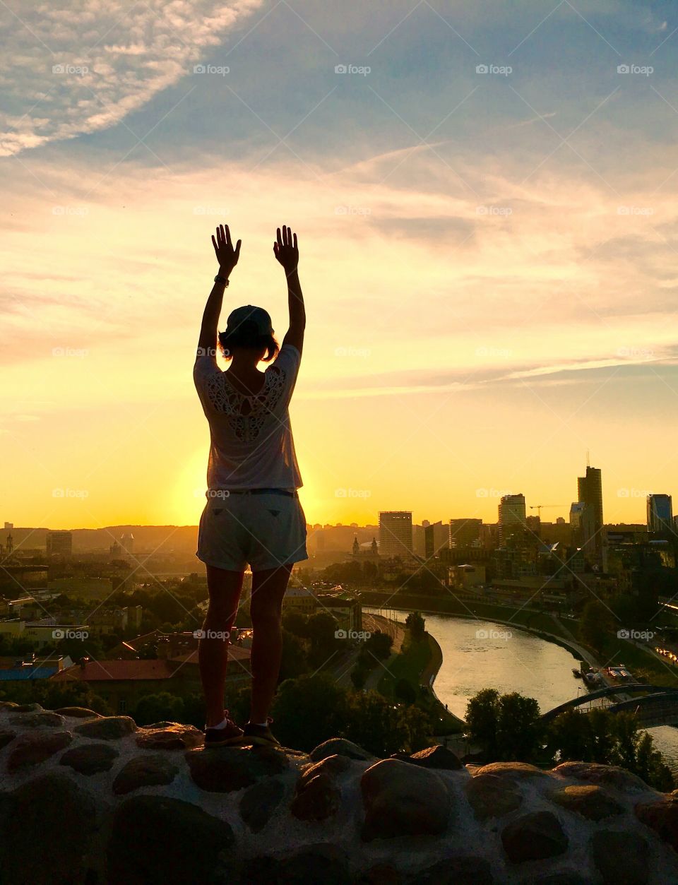 silhouette of girl standing above the city.