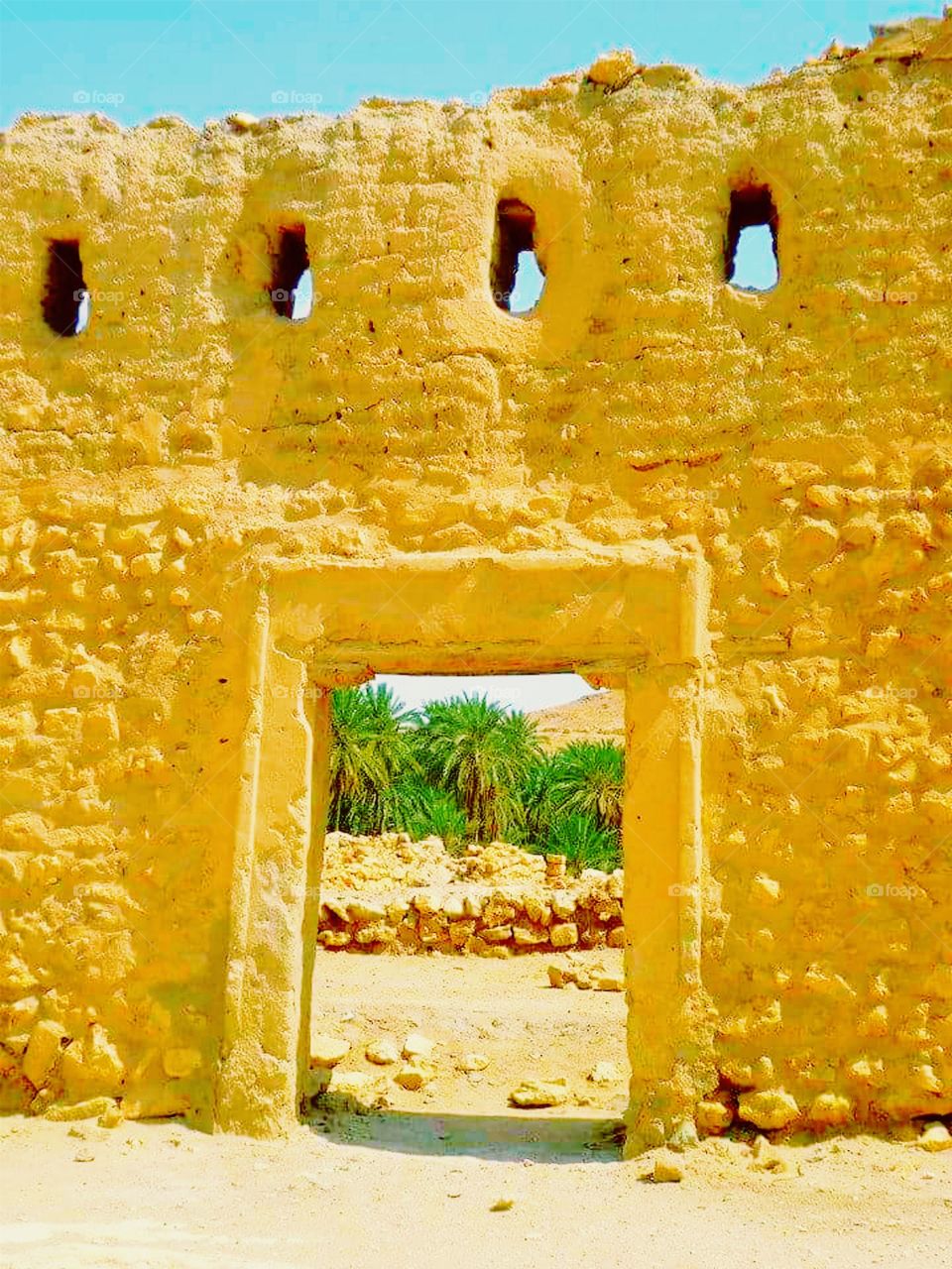 View Through an Ancient Stone Doorway to a Desert Oasis. Location: northern edge of the Sahara desert, Tunisia