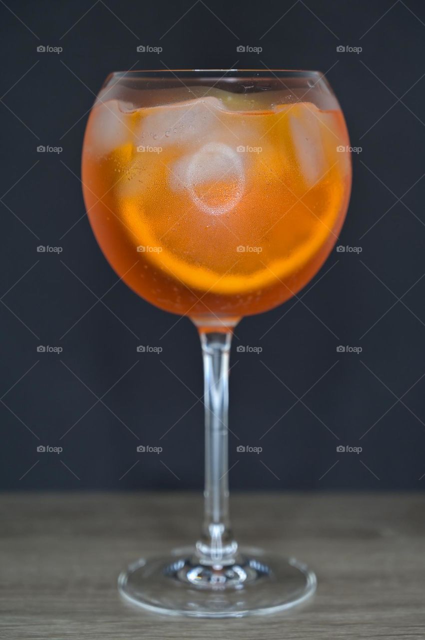 Orange drink in a round glass on the table with a black background