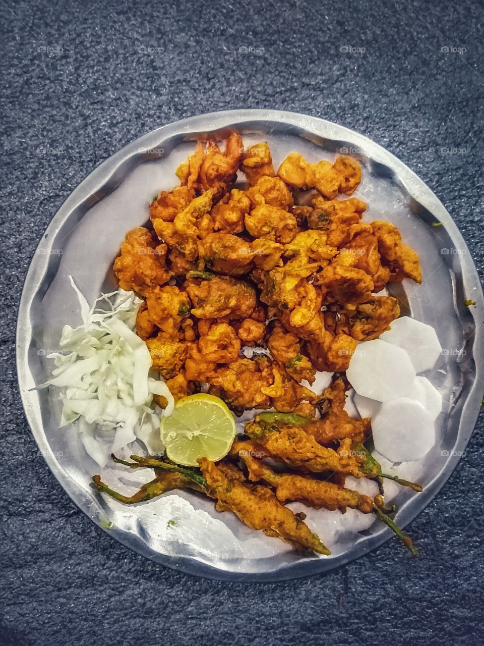 Mix spicy pakora or Pakoda, chilli pakora snacks plate, famous crispy snacks famous in North India.