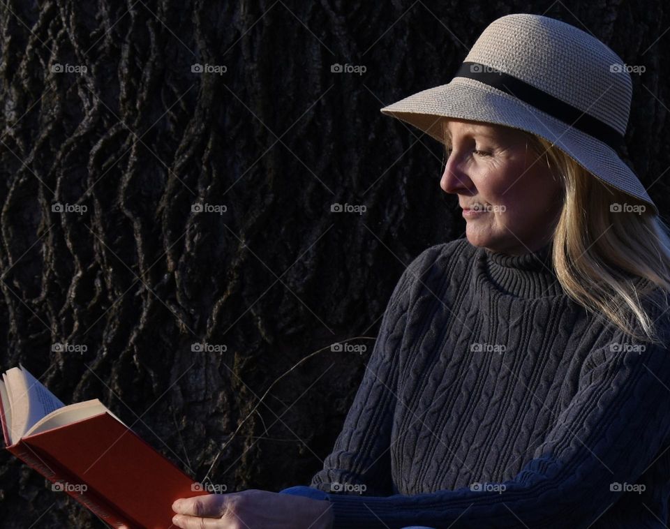 Woman reading a book in the evening sun