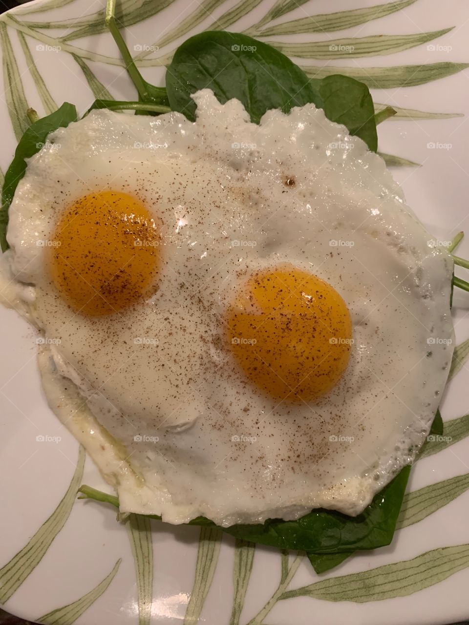 Happy eggs sunny side up over spinach 