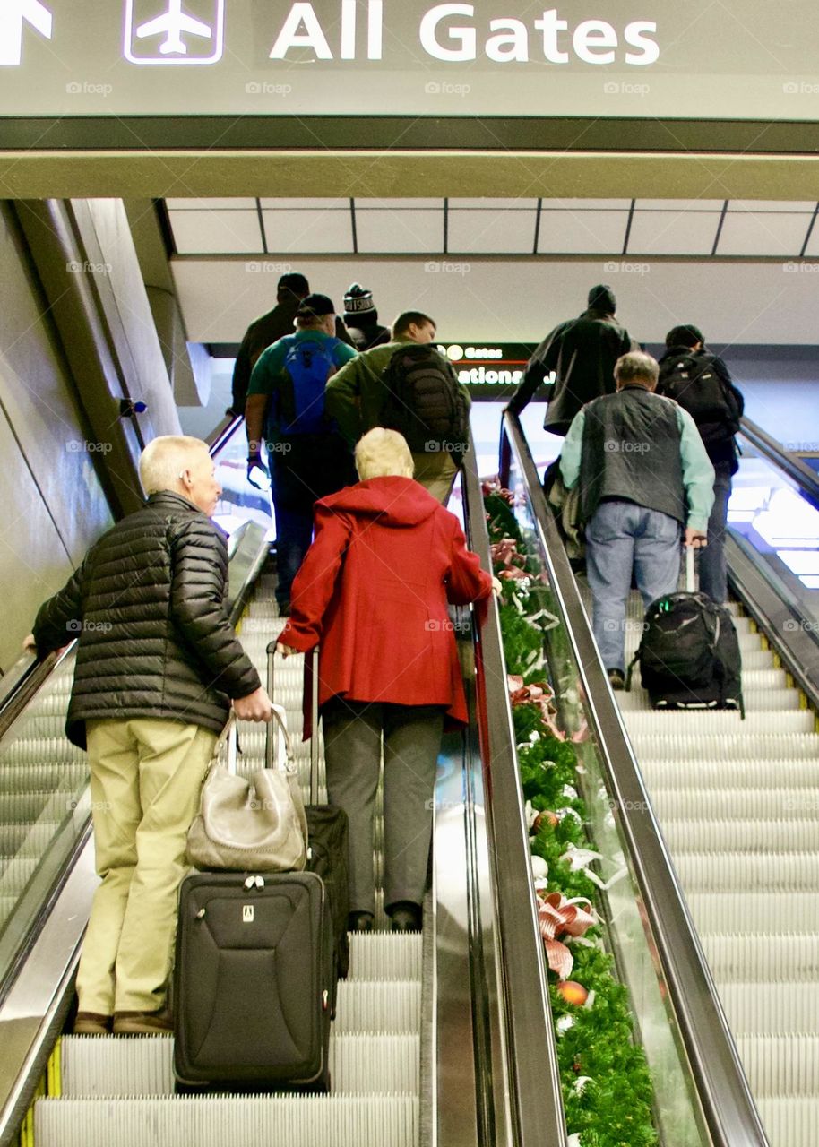 Travelers on an escalator 