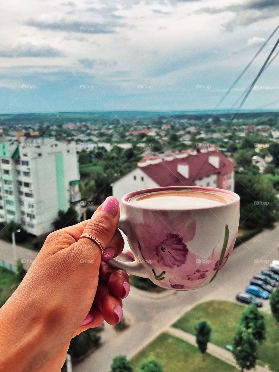 sunset sky, view of the city from the window and a cup of cappuccino
