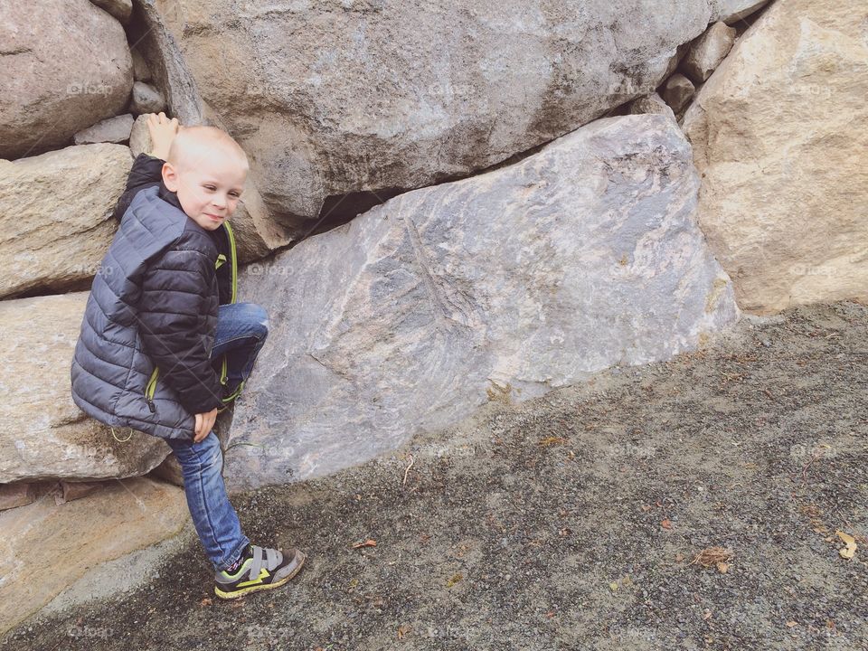 Boy climbing. A boy at a stone wall