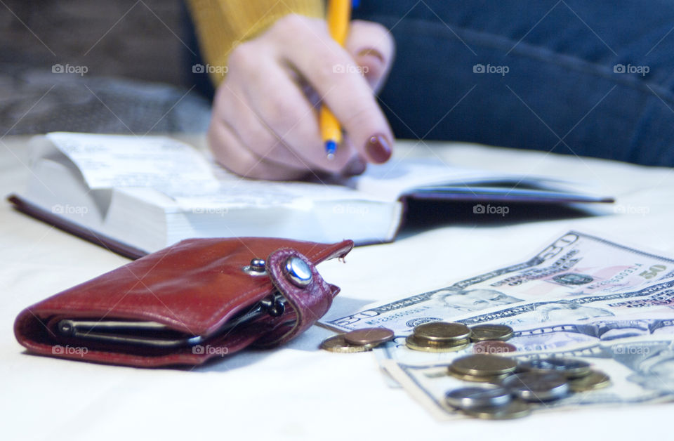 Girl makes notes in a notebook, keeps a record of finances