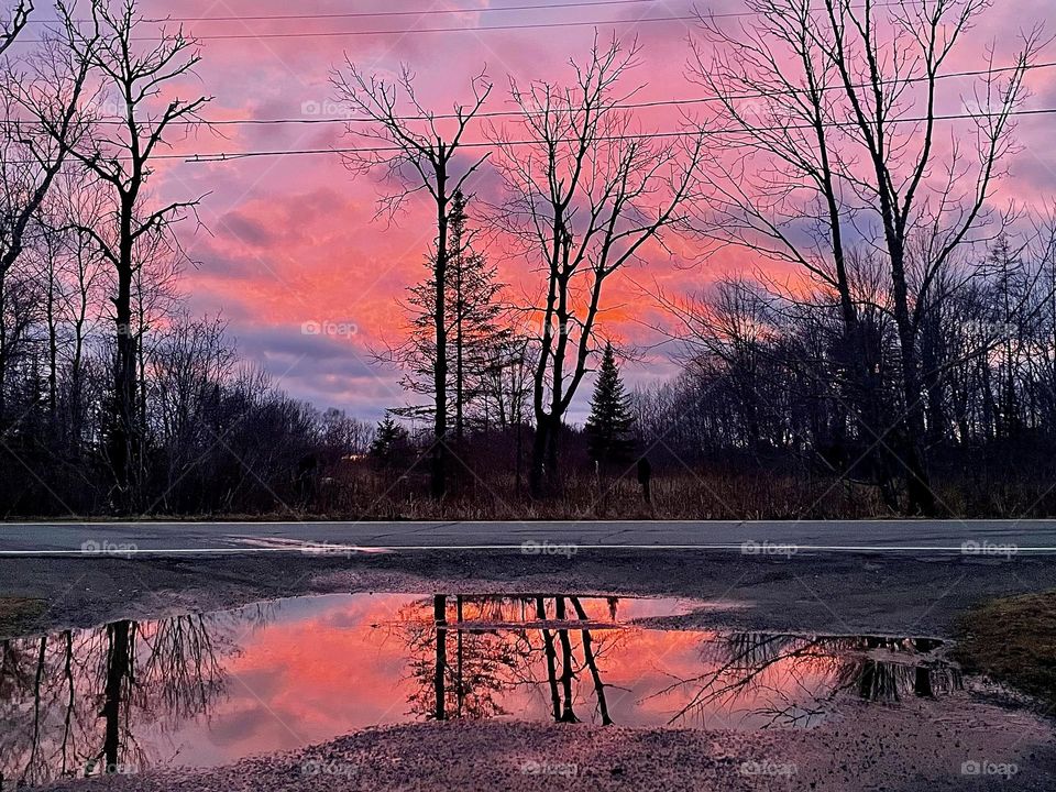 Red Sky at Night.  Tare reflected in a puddle at the end of a driveway during a fiery sunset.