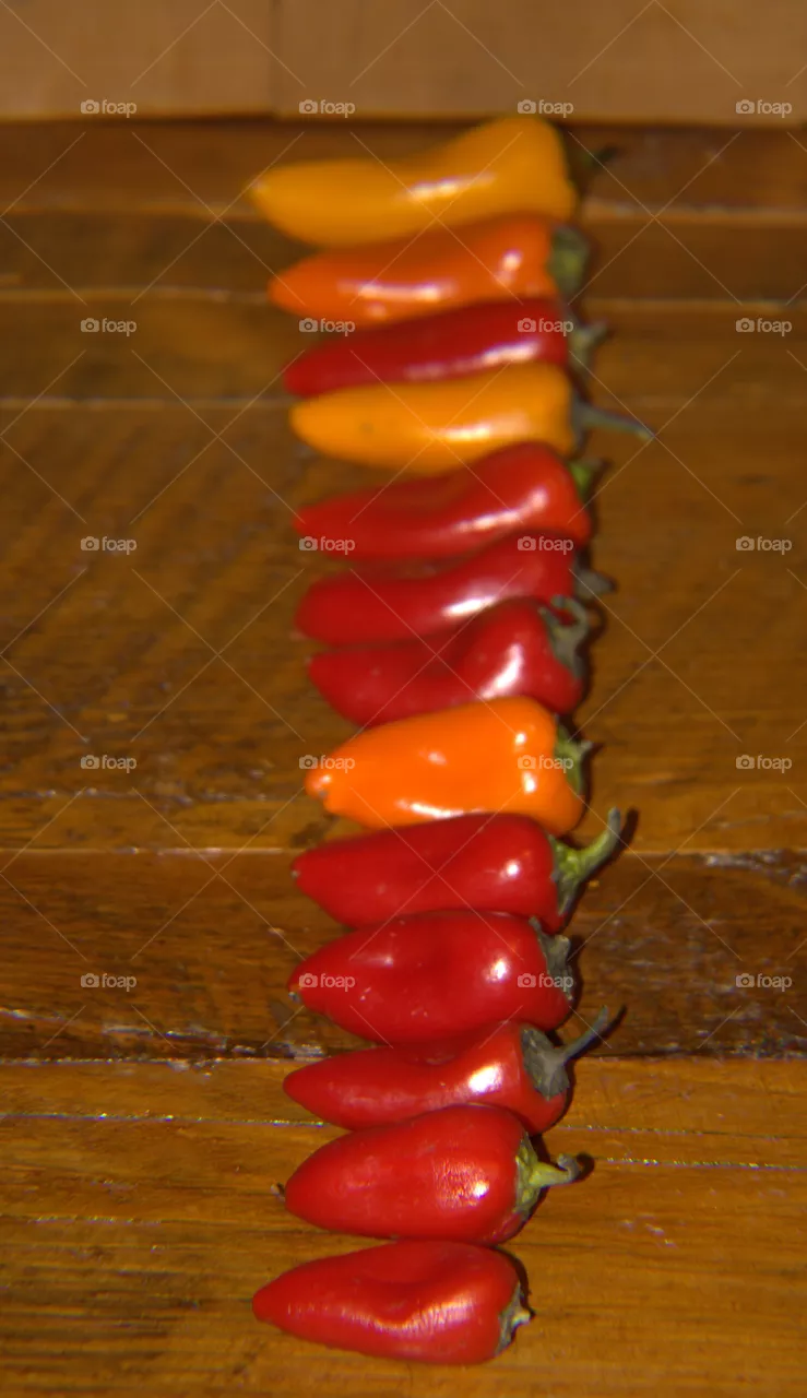 Yellow, Orange, & Red Heirloom Peppers Lined Up By Size