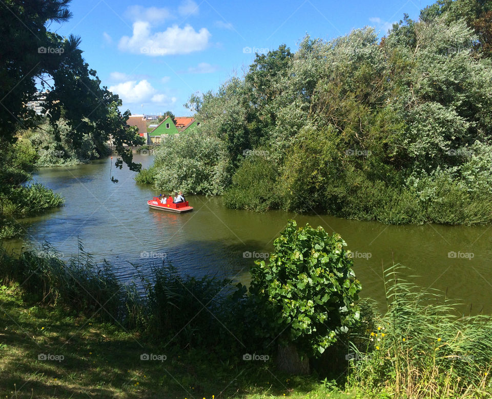 Sunny afternoon in the park. Family in a boat. 