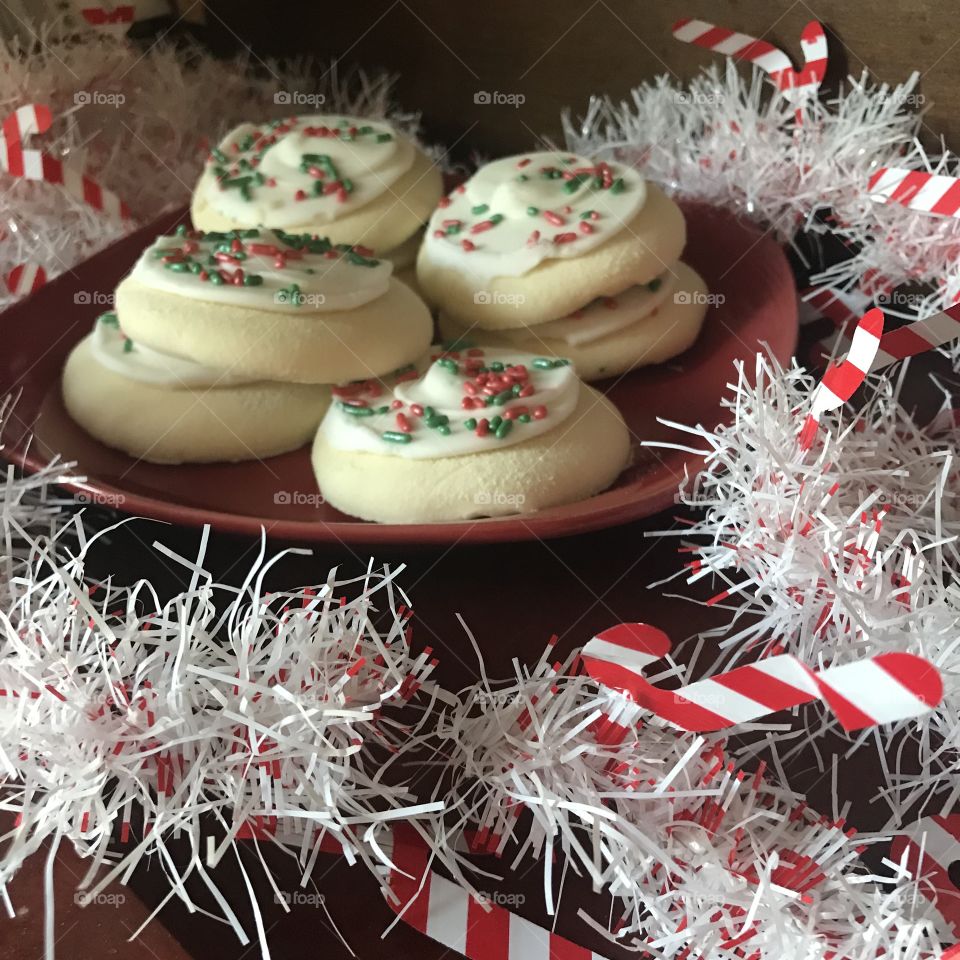 A Beautiful plate of Christmas sugar cookies surrounded by white candy cane garland 
